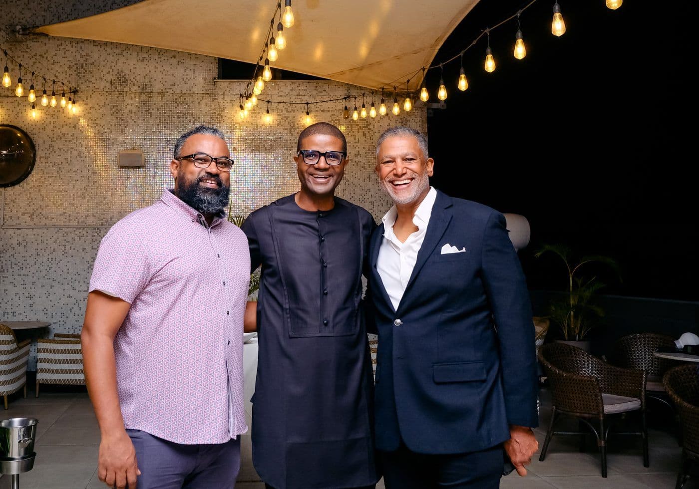 Three delegates standing together at an evening reception.