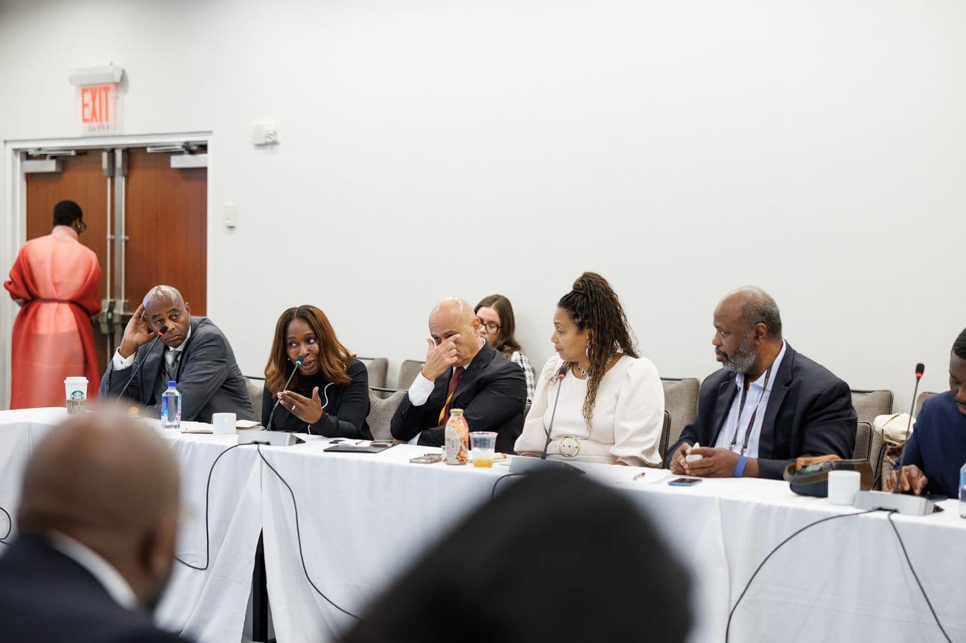 Panellists seated behind a draped table during a sideline session.